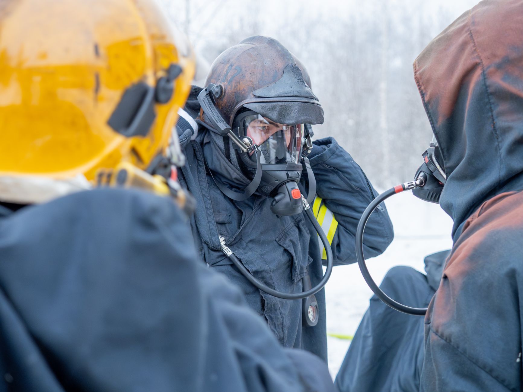 men in black costumes with gas masks