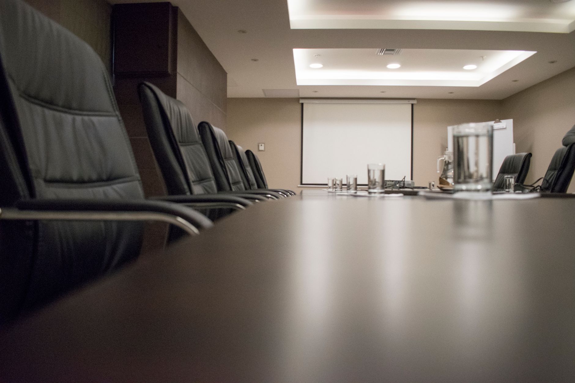 black leather office rolling chairs beside brown wooden table